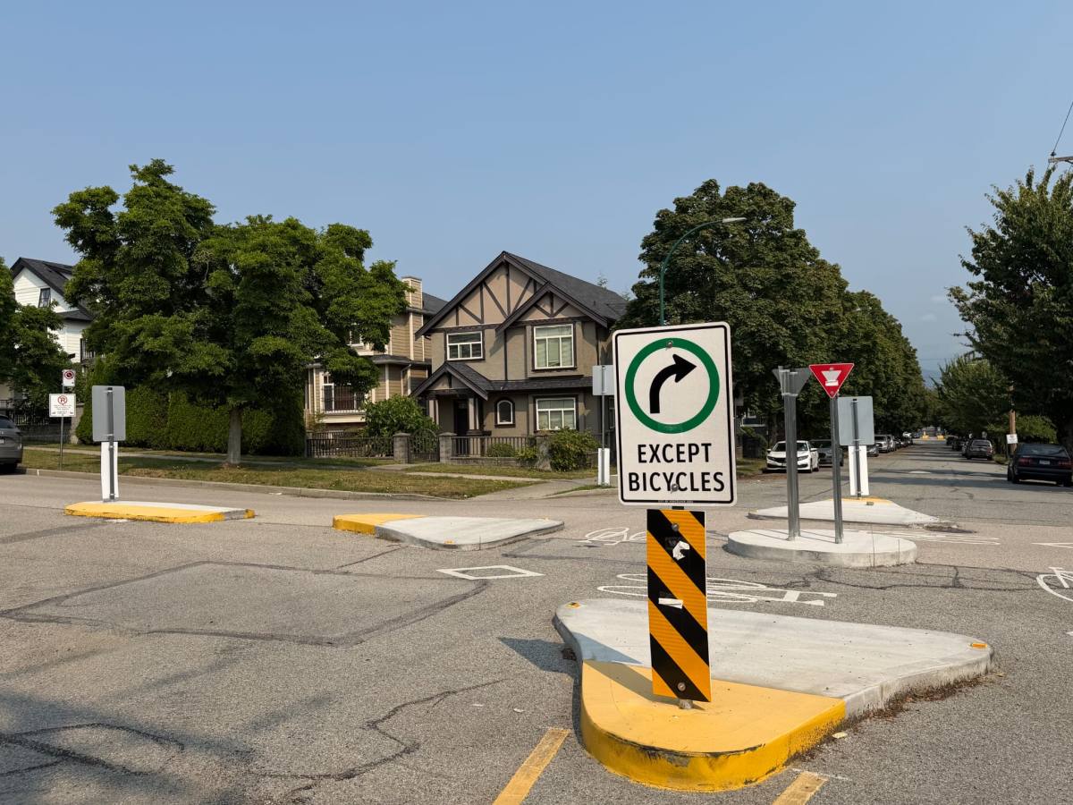 Concrete traffic barriers and a mandatory turn sign at a residential East Vancouver intersection